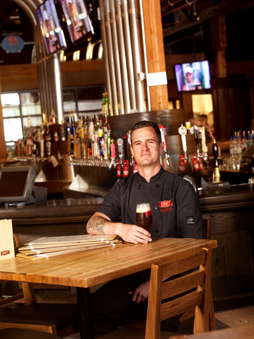 Calgary Beverage Photographer. Chef sitting at table with beer in hand.