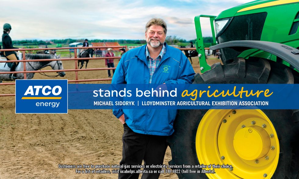 Calgary People Photographer. Man leaning against tractor tire. Lloydminster agricultural exhibition association.